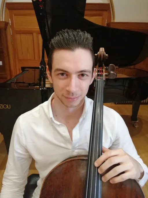 a beautiful picture of Nicola Siagri sitting with the cello